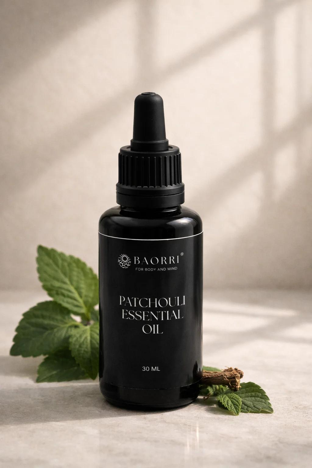 patchouli essential oil in a glass black bottle on light grey stone effect surface.