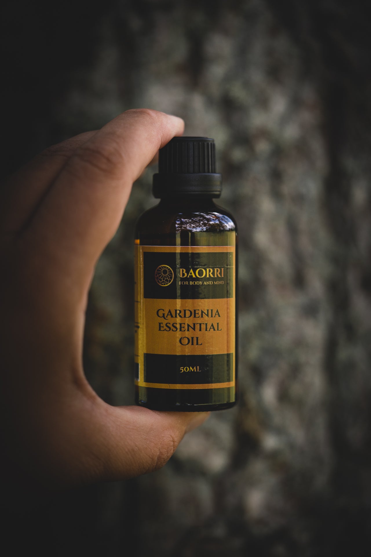 gardenia essential oil in hands on the three background