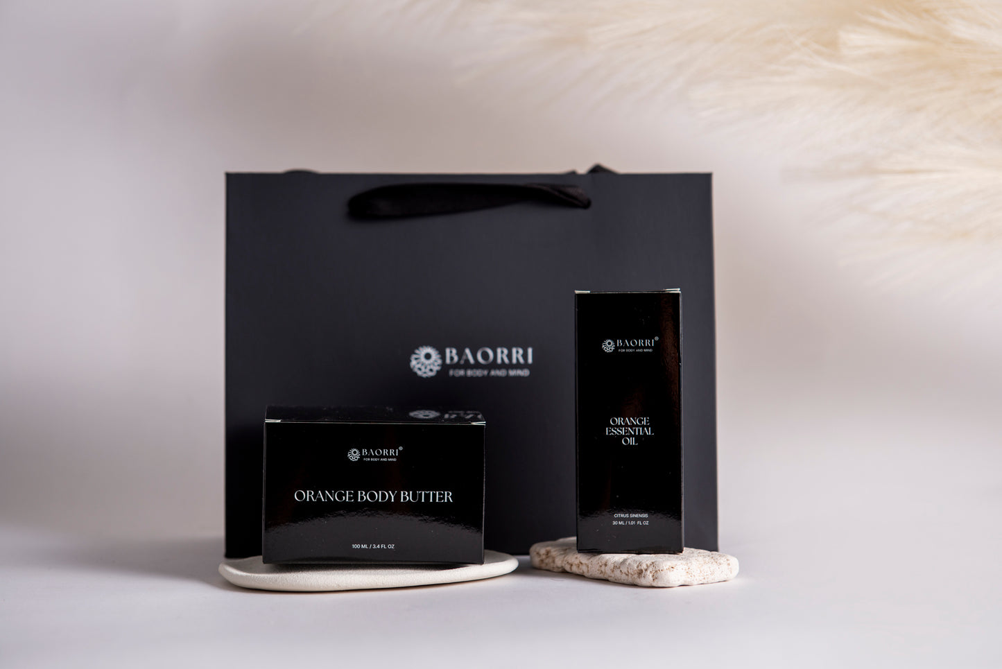 orange body butter and orange essential oil in a grey background