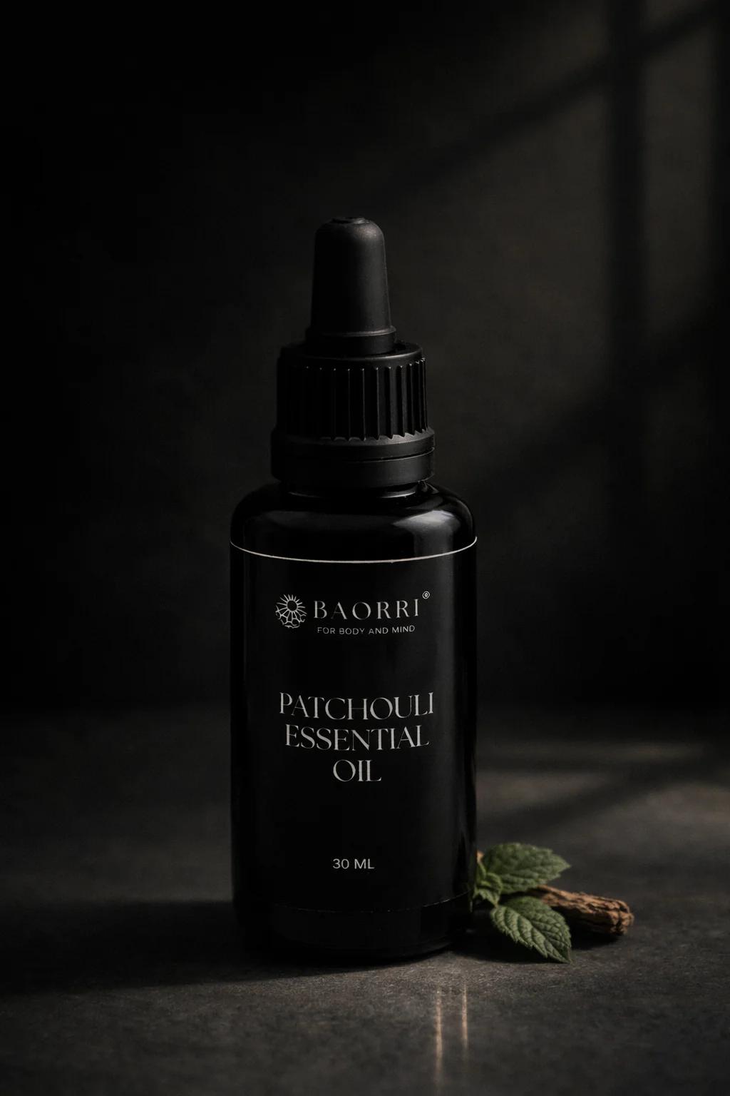 patchouli essential oil in a glass black bottle on stone effect grey surface.